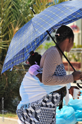 Madre africana con figlia sulle spalle photo