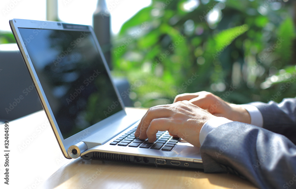 Fototapeta Person Typing on a modern laptop in an office