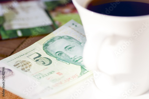 Fünf-Singapur-Dollar Schein neben Kaffeetasse © Finanzfoto