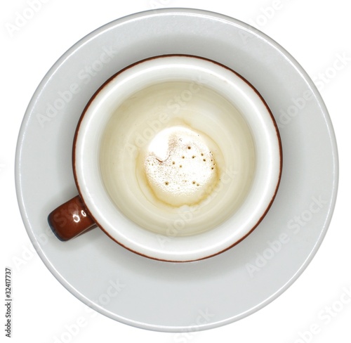 Fondo di caffè in tazza marrone su piatto bianco
