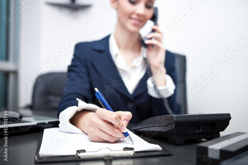 businesswoman writing an appointment and using phone photo