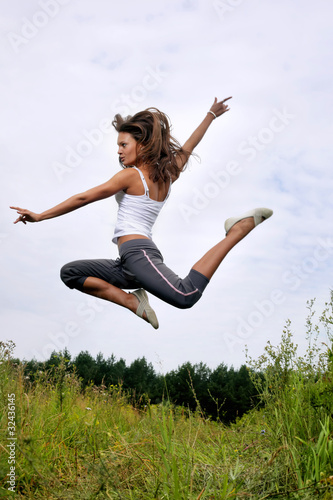beauty girl jumping on green grass