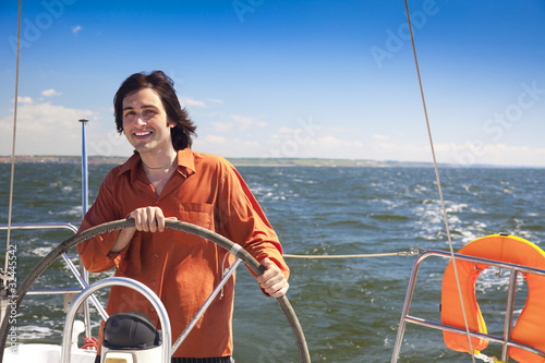 Young  skipper driving sailboat © Taiga