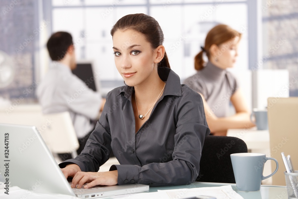 Young female in office colleagues working behind Young female in office colleagues working behind