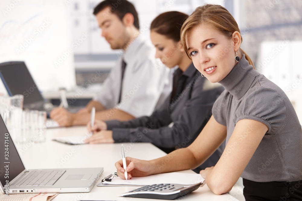 Young businesspeople sitting at meeting table Young businesspeople sitting at meeting table