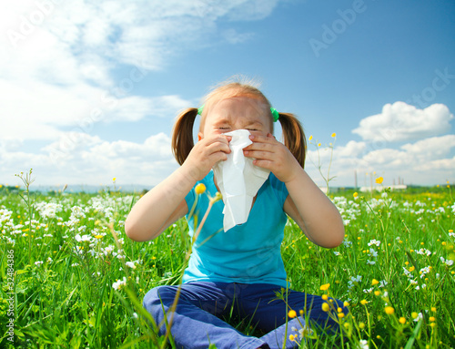 Little girl is blowing her nose photo