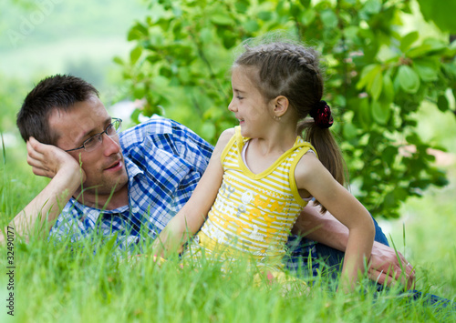 Happy father playing with his daughter in beautiful green grass © Smailhodzic