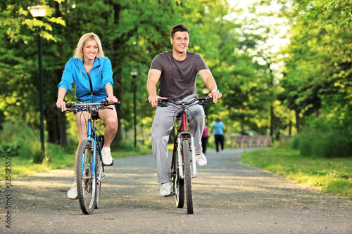 Happy couple biking in the park