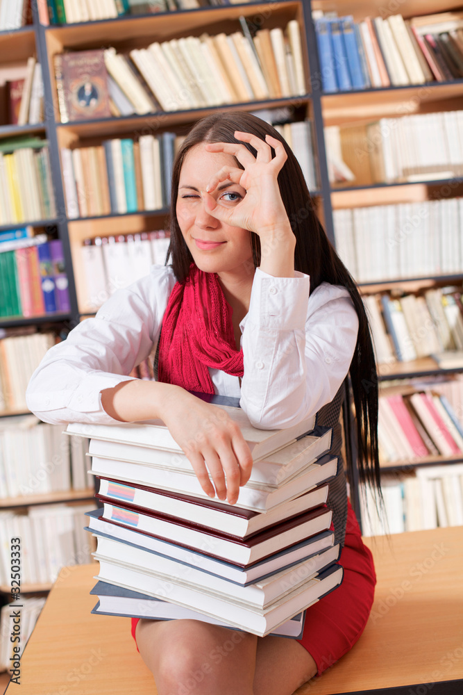 Pretty student with books showing OK sign Pretty student with books showing OK sign
