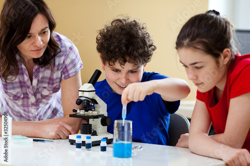 Kids examining preparation under the microscope