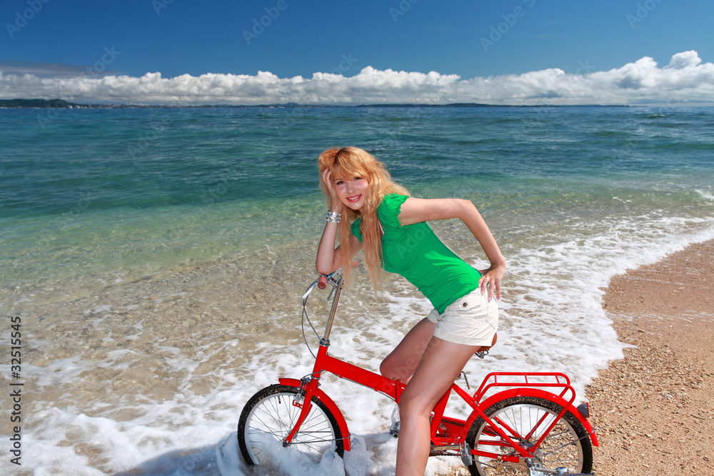 久高島のビーチでサイクリングを楽しむ笑顔の女性