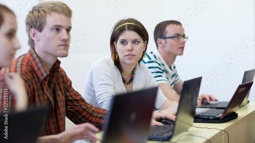 young, pretty female college student sitting in a classroom