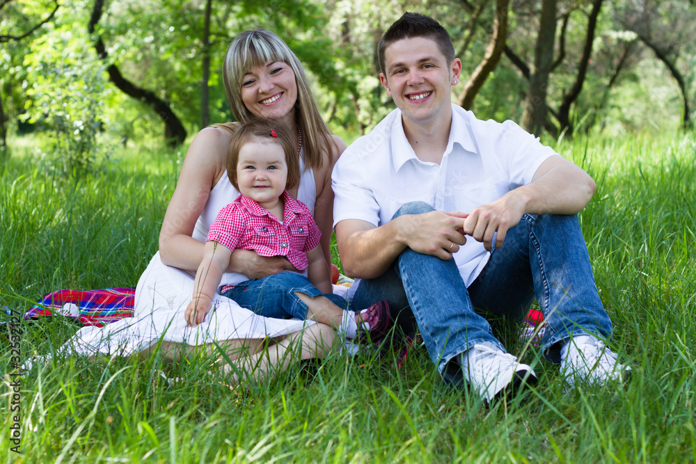 Fototapeta premium Young family of three on a picnic