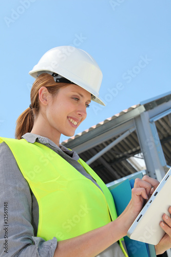 Woman engineer checking building plan on touchpad