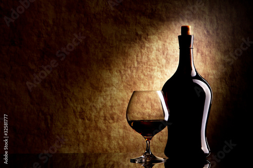 Cognac Glass and Bottle on a old stone background