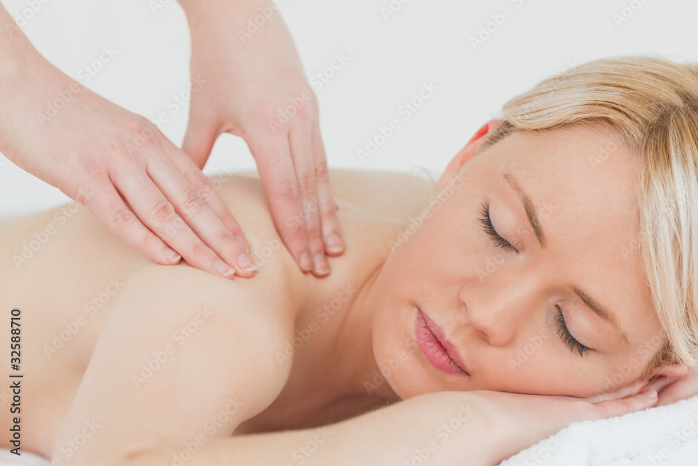 Closeup of young beautiful blonde woman receiving a back massage