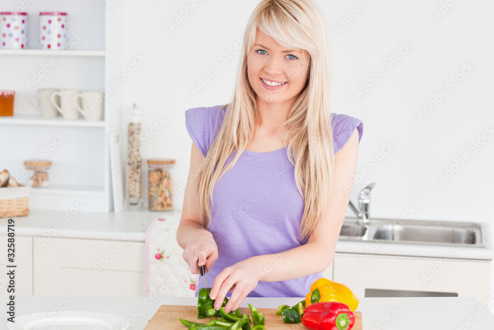 Beautiful blonde woman cutting vegetables in modern kitchen inte Beautiful blonde woman cutting vegetables in modern kitchen inte