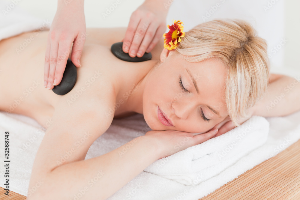 Young woman receiving a massage with hot stones Young woman receiving a massage with hot stones