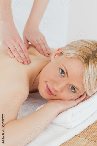 Closeup of young cute blonde female receiving a back massage