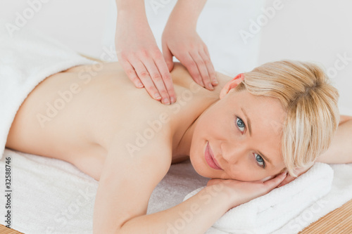Closeup of young cute blonde woman receiving a back massage in a