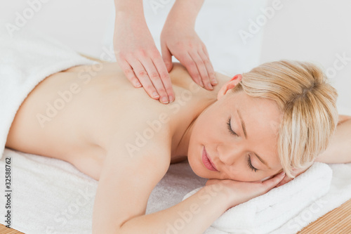 Closeup of young gorgeous blonde woman receiving a back massage