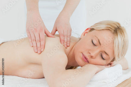 Closeup of young attractive blonde female receiving a back massa