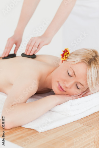 Pretty woman receiving a massage with hot stones