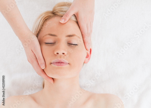 Cute young woman getting a massage on her face