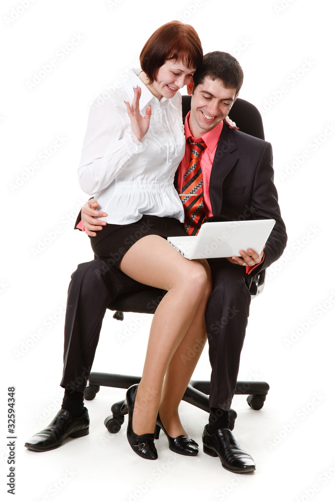 Fototapeta premium Young man and woman sitting in a chair, looking at laptop.
