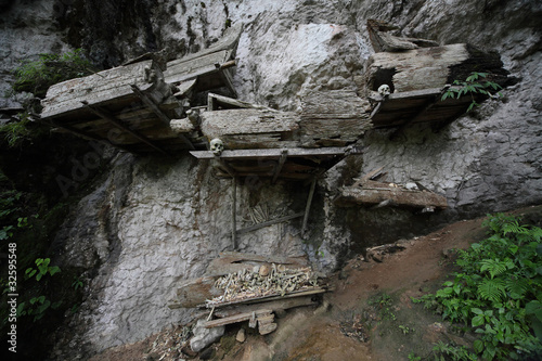 Groups of old family coffins with bones hanging on a rock. Tana Toraja region. Sulawesi island. Indonesia photo