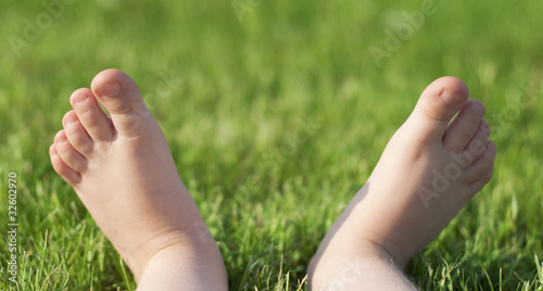 Child's barefeet on green grass © raysay