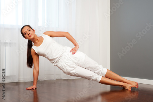 young woman practicing yoga in room