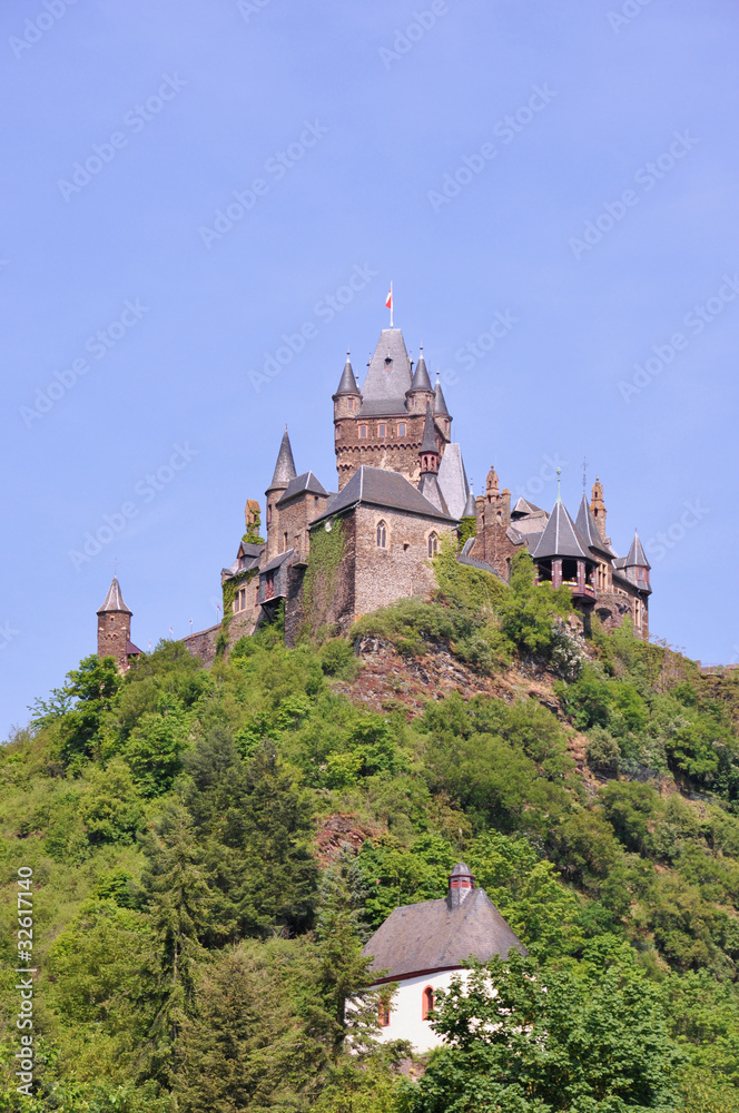 German castle on top of a hill with chapel just beneath