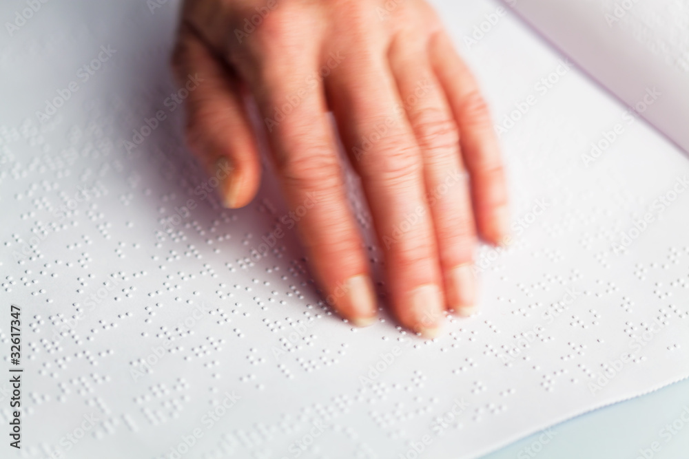 Braille and finger. Book in Braille