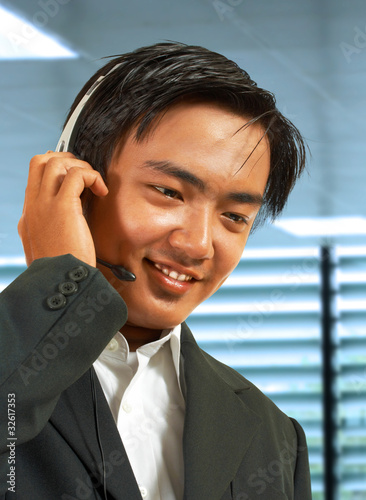 Male Sales Representative In His Office Talking On A Headset