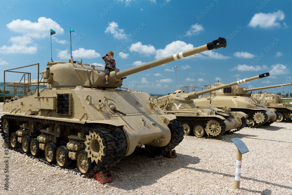 Cute boy saluting on the israeli tank. Museum of tanks. Israel. Cute boy saluting on the israeli tank. Museum of tanks. Israel.