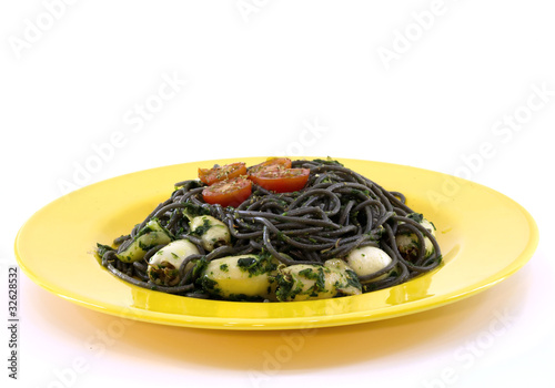 a yellow plate with black pasta and squid