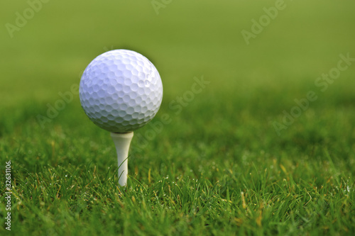 Golf ball on tee over a green