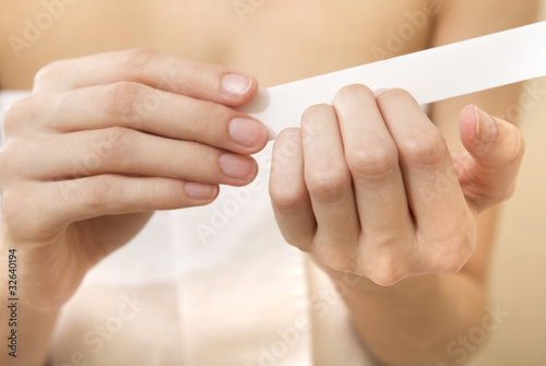 Картината върху платно Woman polishing fingernails with the nail file