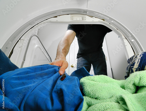 Картината върху платно Removing Laundry from a Dryer