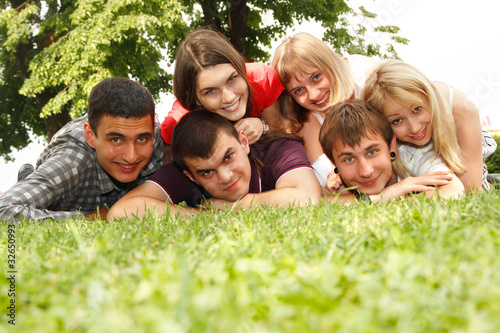 students happy friends group lying on grass