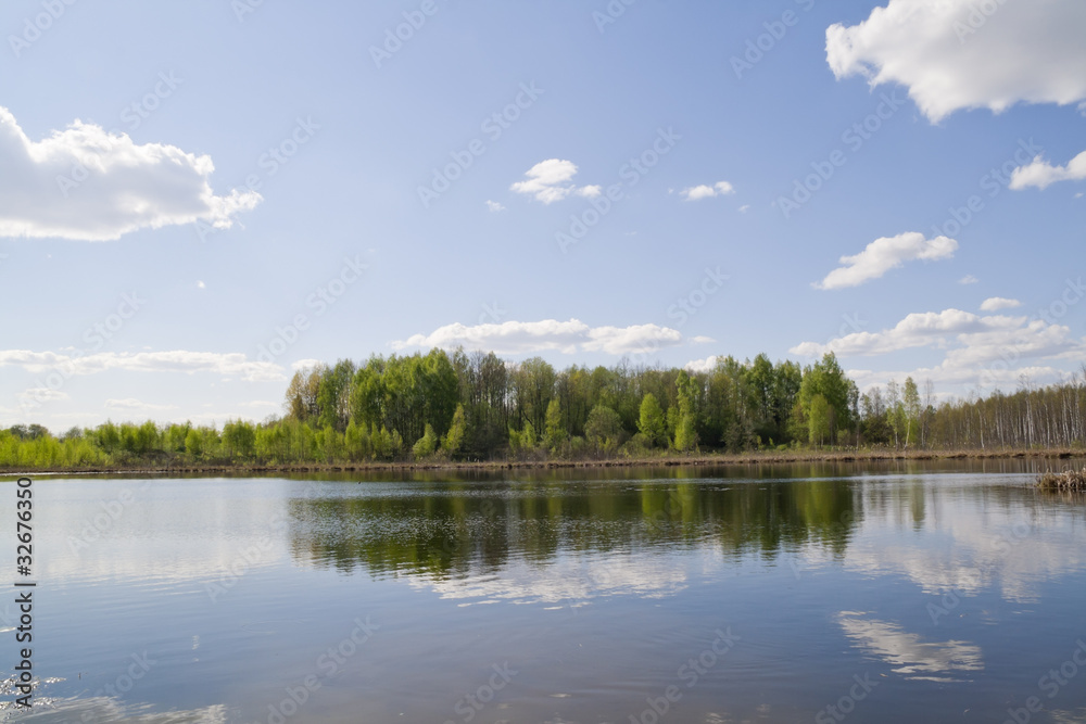 Reflections of the spring sky in wood lake