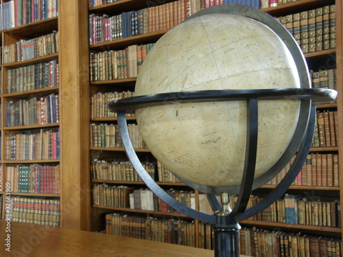 Rows of books on library shelves and a big globe