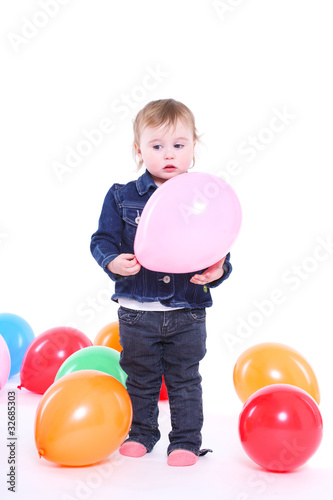 little girl plays with color balloons