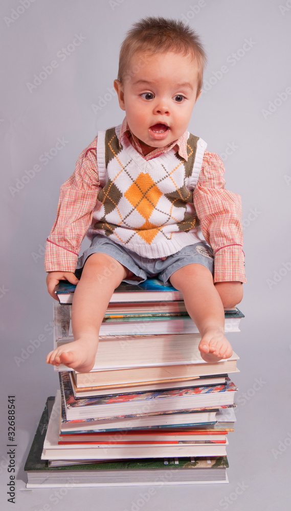 enfant expressif sur une pile de gros livres enfant expressif sur une pile de gros livres
