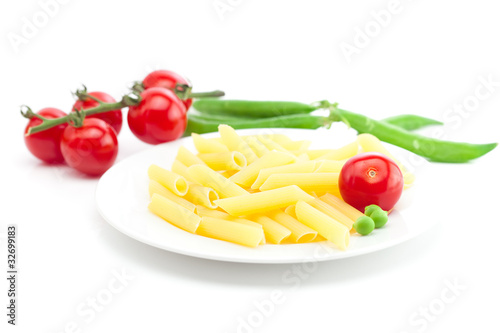 tomato, peas and pasta on a plate isolated on white