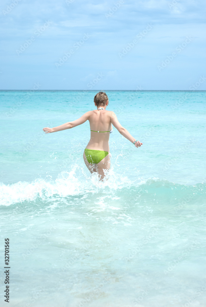 Young woman running into the ocean Young woman running into the ocean