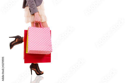 waist-down view of woman carrying shopping bags, isolated on whi