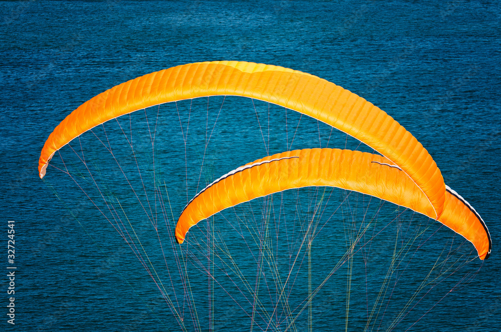 Deux voiles jaunes de parapentes seules sur fond bleu Deux voiles jaunes de parapentes seules sur fond bleu