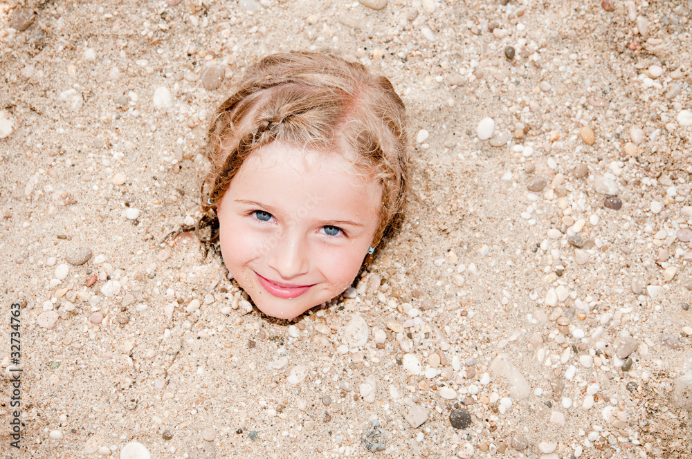 Little girl buried in the sand of the beach Stock Photo Adobe Stock
